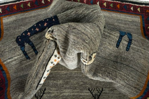 Corner detail of 2000s Persian Gabbeh rug showing border pattern and Wool pile