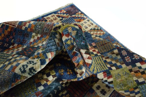 Corner detail of 2000s Persian Gabbeh rug showing border pattern and Wool pile