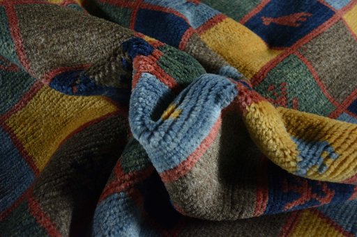 Corner detail of 2000s Persian Gabbeh rug showing border pattern and Wool pile