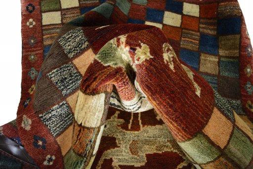 Corner detail of 2000s Persian Gabbeh rug showing border pattern and Wool pile