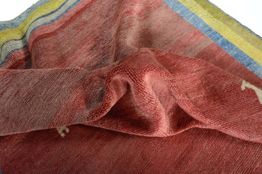 Corner detail of 2000s Persian Gabbeh rug showing border pattern and Wool pile