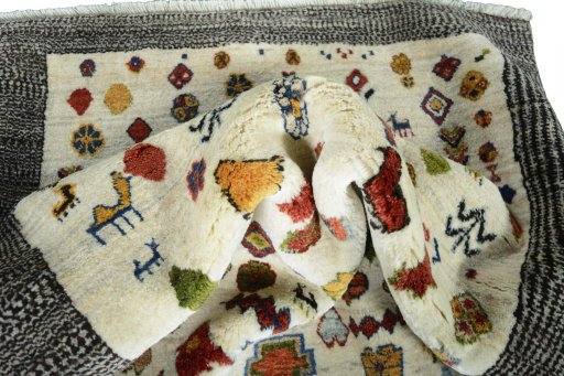 Corner detail of 2000s Persian Gabbeh rug showing border pattern and Wool pile