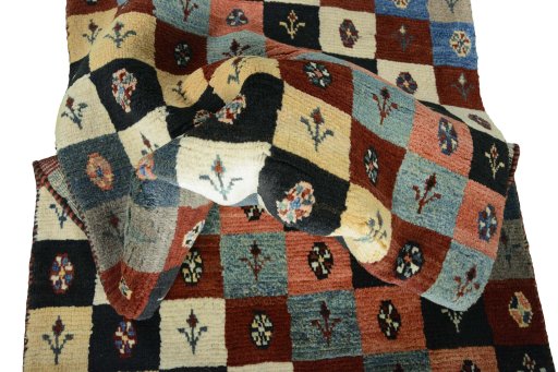 Corner detail of 2000s Persian Gabbeh rug showing border pattern and Wool pile