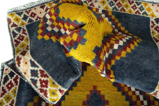 Corner detail of 2000s Persian Gabbeh rug showing border pattern and Wool pile