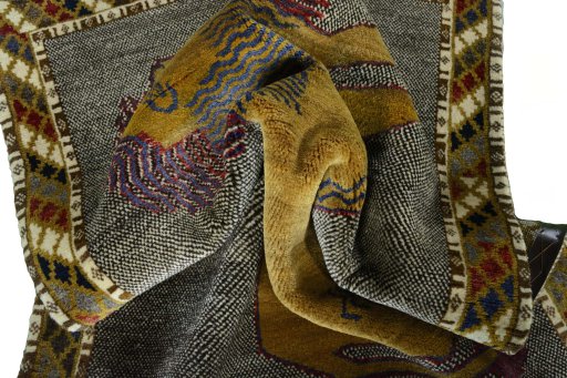 Corner detail of 2000s Persian Gabbeh rug showing border pattern and Wool pile