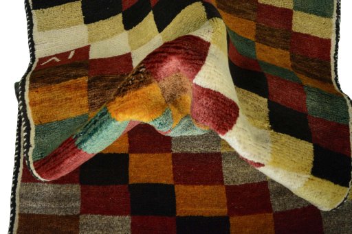 Corner detail of 2000s Persian Gabbeh rug showing border pattern and Wool pile