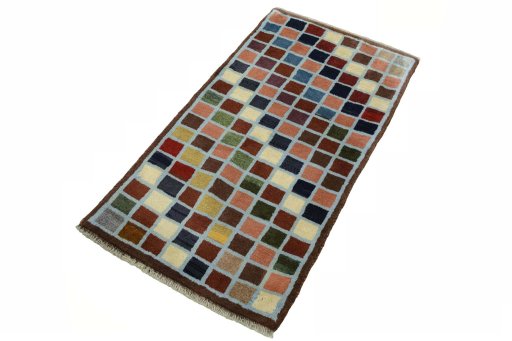 Corner detail of 2000s Persian Gabbeh rug showing border pattern and Wool pile