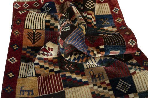 Corner detail of 2000s Persian Gabbeh rug showing border pattern and Wool pile