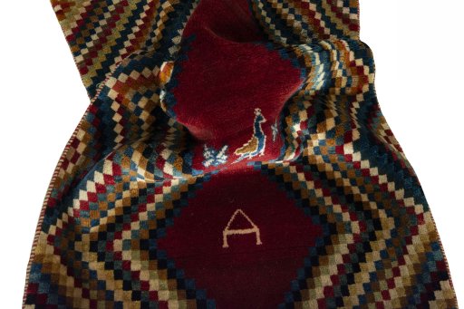 Corner detail of 2000s Persian Gabbeh rug showing border pattern and Wool pile