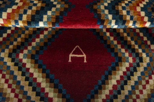 Full view of 2000s Persian Gabbeh rug from Iran / Persia, 137 × 81 cm in Red tones