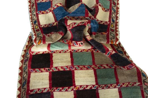 Corner detail of 2000s Persian Gabbeh rug showing border pattern and Wool pile