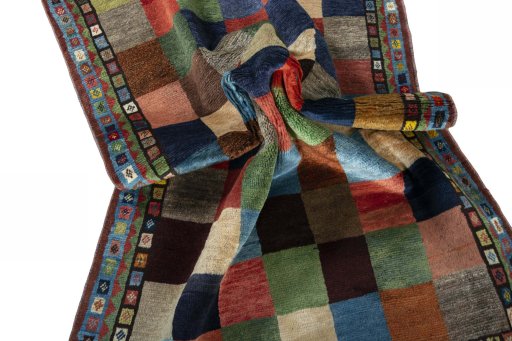 Corner detail of 2000s Persian Gabbeh rug showing border pattern and Wool pile