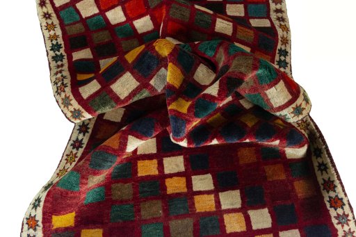 Corner detail of 2000s Persian Gabbeh rug showing border pattern and Wool pile