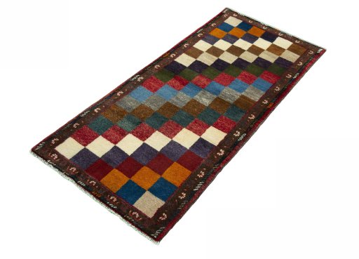 Corner detail of 2000s Persian Gabbeh rug showing border pattern and Wool pile