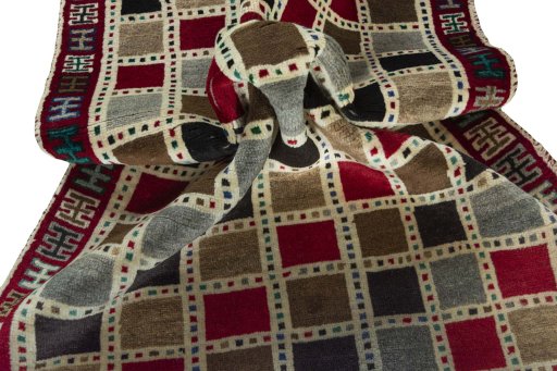 Corner detail of 2000s Persian Gabbeh rug showing border pattern and Wool pile