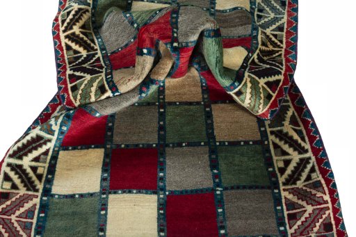 Corner detail of 2000s Persian Gabbeh rug showing border pattern and Wool pile