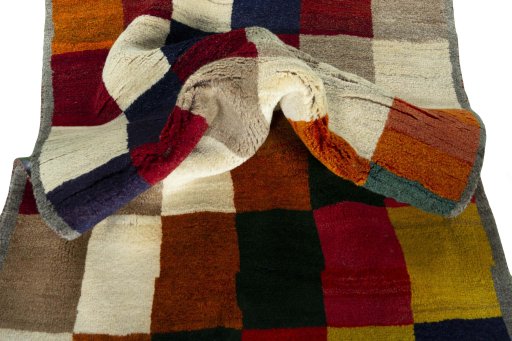 Corner detail of 2000s Persian Gabbeh rug showing border pattern and Wool pile