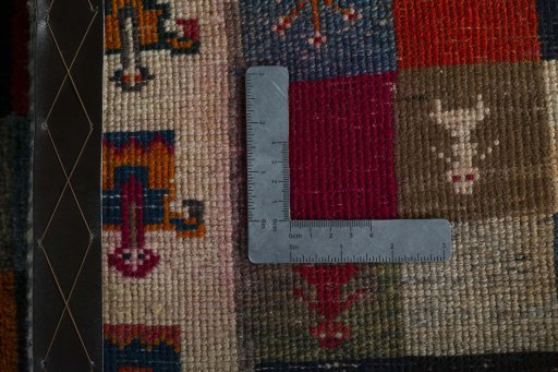 Corner detail of 2000s Persian Gabbeh rug showing border pattern and Wool pile