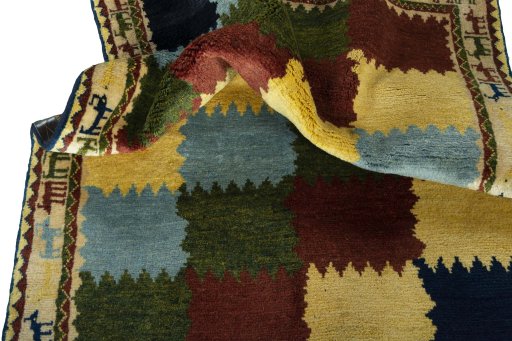 Corner detail of 2000s Persian Gabbeh rug showing border pattern and Wool pile