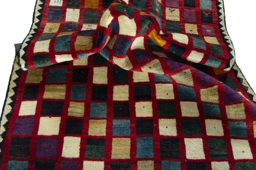 Corner detail of 2000s Persian Gabbeh rug showing border pattern and Wool pile