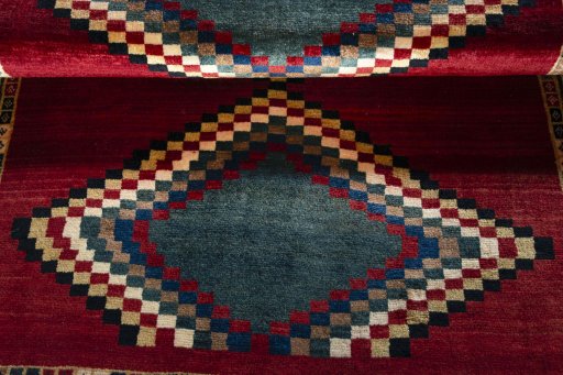 Full view of 2000s Persian Gabbeh rug from Iran / Persia, 182 × 132 cm in Red tones