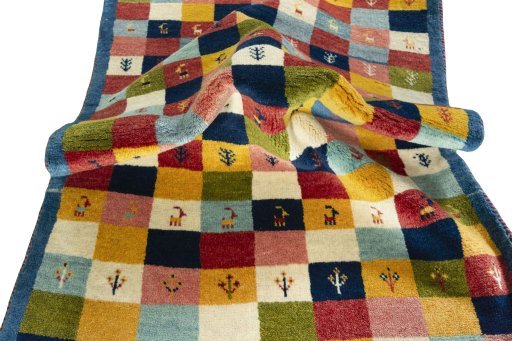 Corner detail of 2000s Persian Gabbeh rug showing border pattern and Wool pile