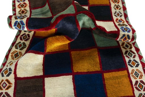 Corner detail of 2000s Persian Gabbeh rug showing border pattern and Wool pile