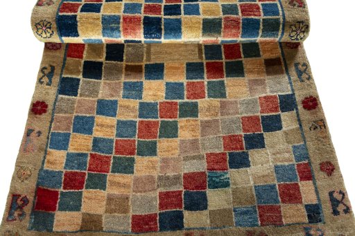Corner detail of 2000s Persian Gabbeh rug showing border pattern and Wool pile