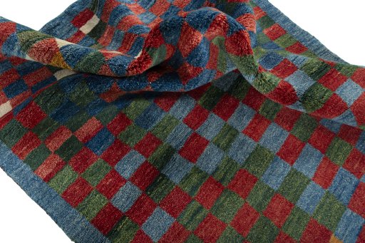 Corner detail of 2000s Persian Gabbeh rug showing border pattern and Wool pile