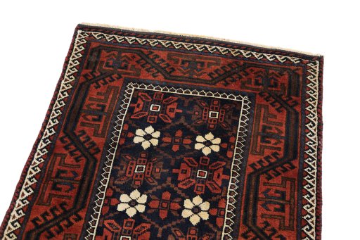 Surface texture of 1900s Baloch rug with natural Wool and intricate pattern