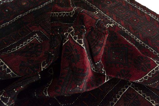 Corner detail of 2000s Baloch rug showing border pattern and Wool pile