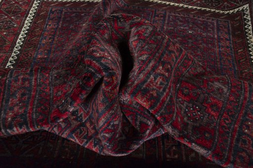 Corner detail of 2000s Baloch rug showing border pattern and Wool pile