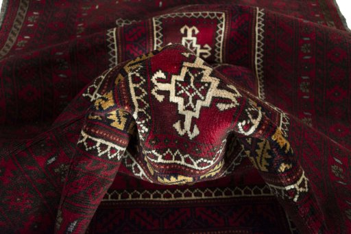 Corner detail of 2000s Baloch rug showing border pattern and Wool pile