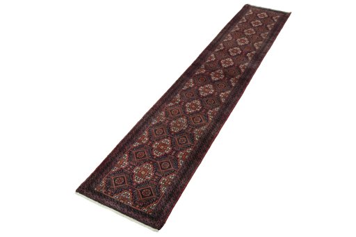Corner detail of 2000s Baloch rug showing border pattern and Wool pile