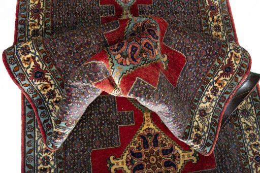 Corner detail of New Senneh rug showing border pattern and Wool pile