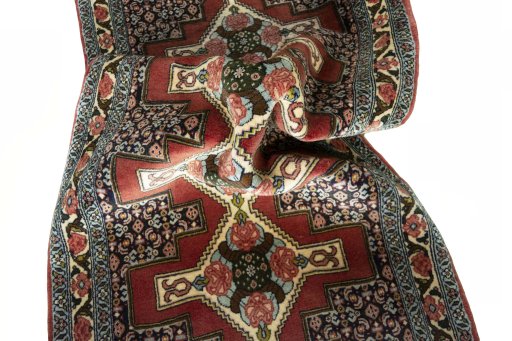 Corner detail of 2000s Senneh rug showing border pattern and Wool pile
