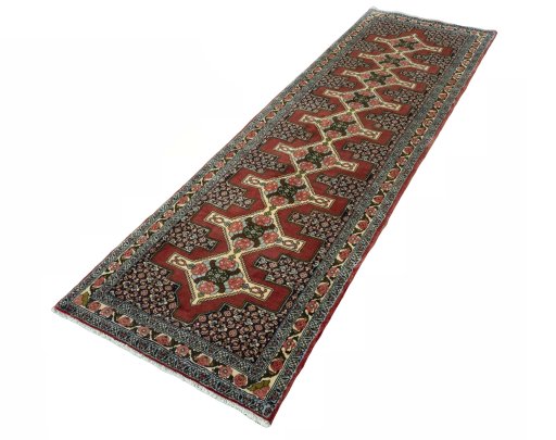 Corner detail of 2000s Senneh rug showing border pattern and Wool pile