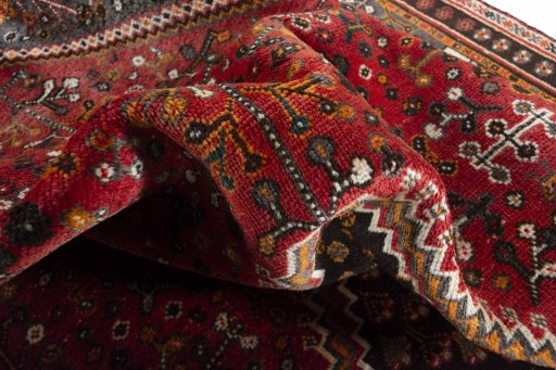 Corner detail of 2000s Shiraz rug showing border pattern and Wool pile