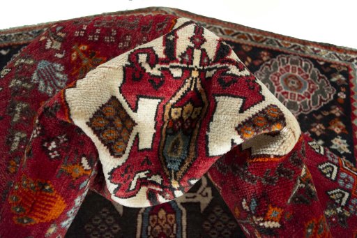 Corner detail of 2000s Shiraz rug showing border pattern and Wool pile