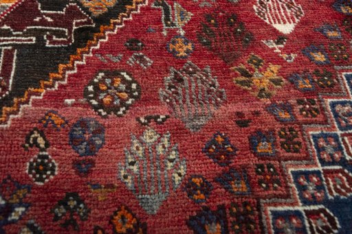 Corner detail of 2000s Shiraz rug showing border pattern and Wool pile