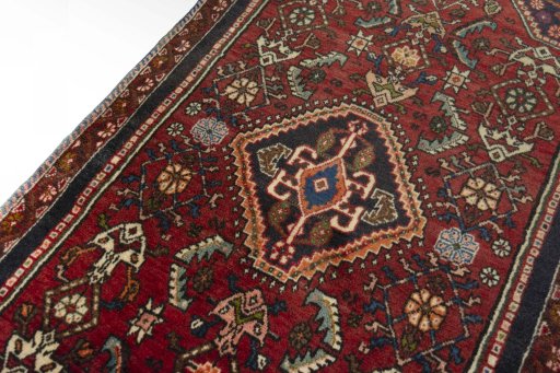Backside of handmade 2000s Shiraz rug showing knot structure and weave density