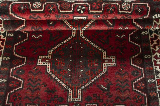 Corner detail of 2000s Shiraz rug showing border pattern and Wool pile