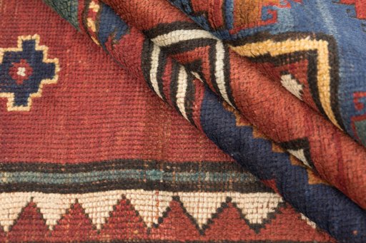 Corner detail of 1900s Kazak rug showing border pattern and Wool pile