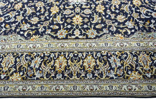Corner detail of 2000s Kashan rug showing border pattern and Wool pile