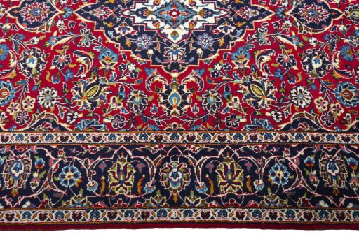 Corner detail of 2000s Kashan rug showing border pattern and Wool pile