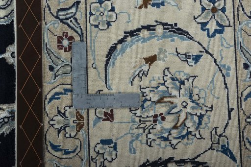 Backside of handmade New Nain rug showing knot structure and weave density