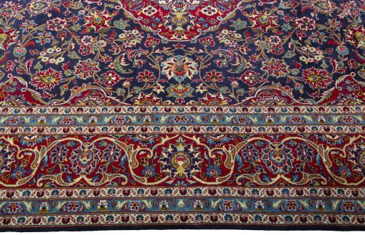 Corner detail of 2000s Kashan rug showing border pattern and Wool pile