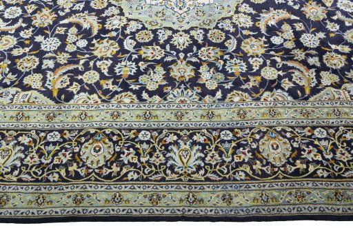 Corner detail of 2000s Kashan rug showing border pattern and Wool pile