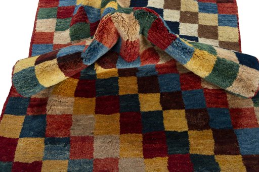 Corner detail of 2000s Persian Gabbeh rug showing border pattern and Wool pile