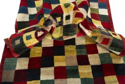 Corner detail of 2000s Persian Gabbeh rug showing border pattern and Wool pile